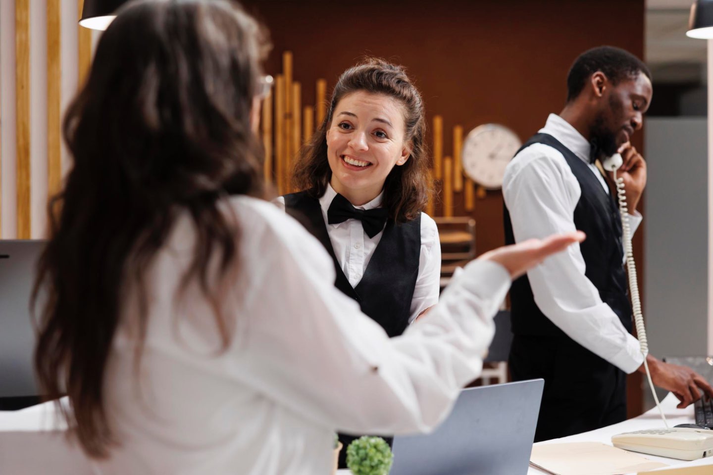 Cum poți evolua într-o carieră de hostess? (fotografie cu o hostess care comunica cu o participanta la o conferinta organizata intr-un hotel)